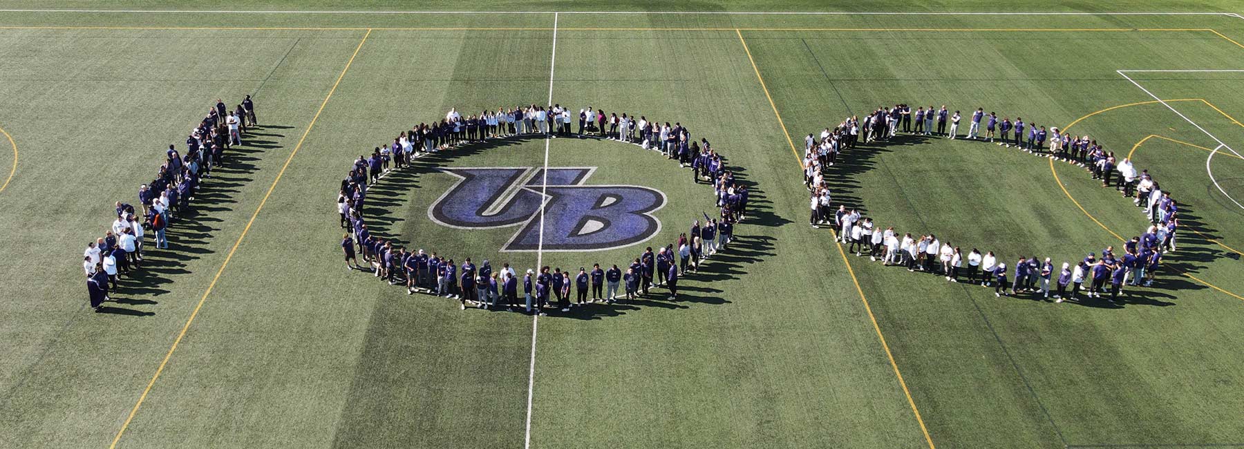 aerial photo of students on the field forming the numbers 100