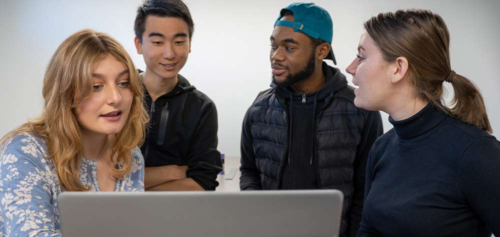 4 students around a laptop