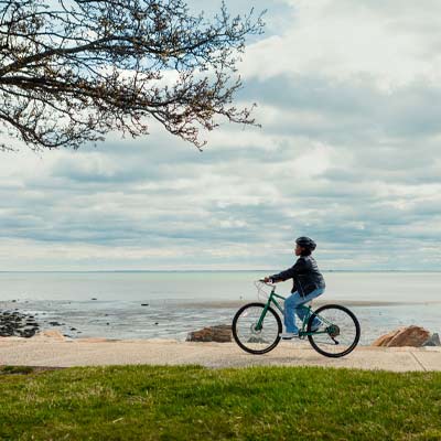 person riding a bicycle along the water
