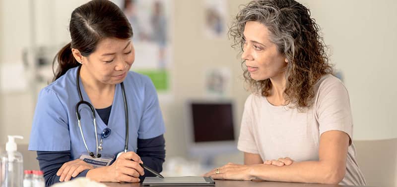 nurse reviewing paperwork with a patient