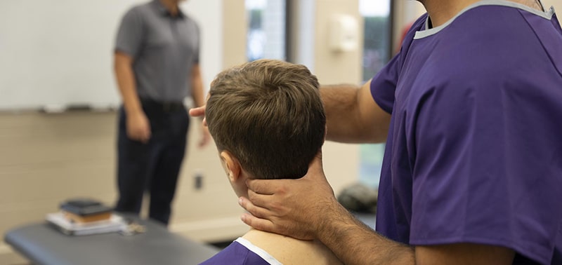 Chiropractic student practicing adjustments in a clinical setting