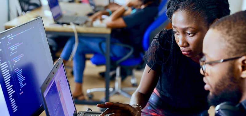 2 people looking at code on a computer screen