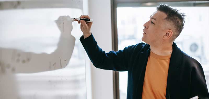 EdD student writing on a whiteboard